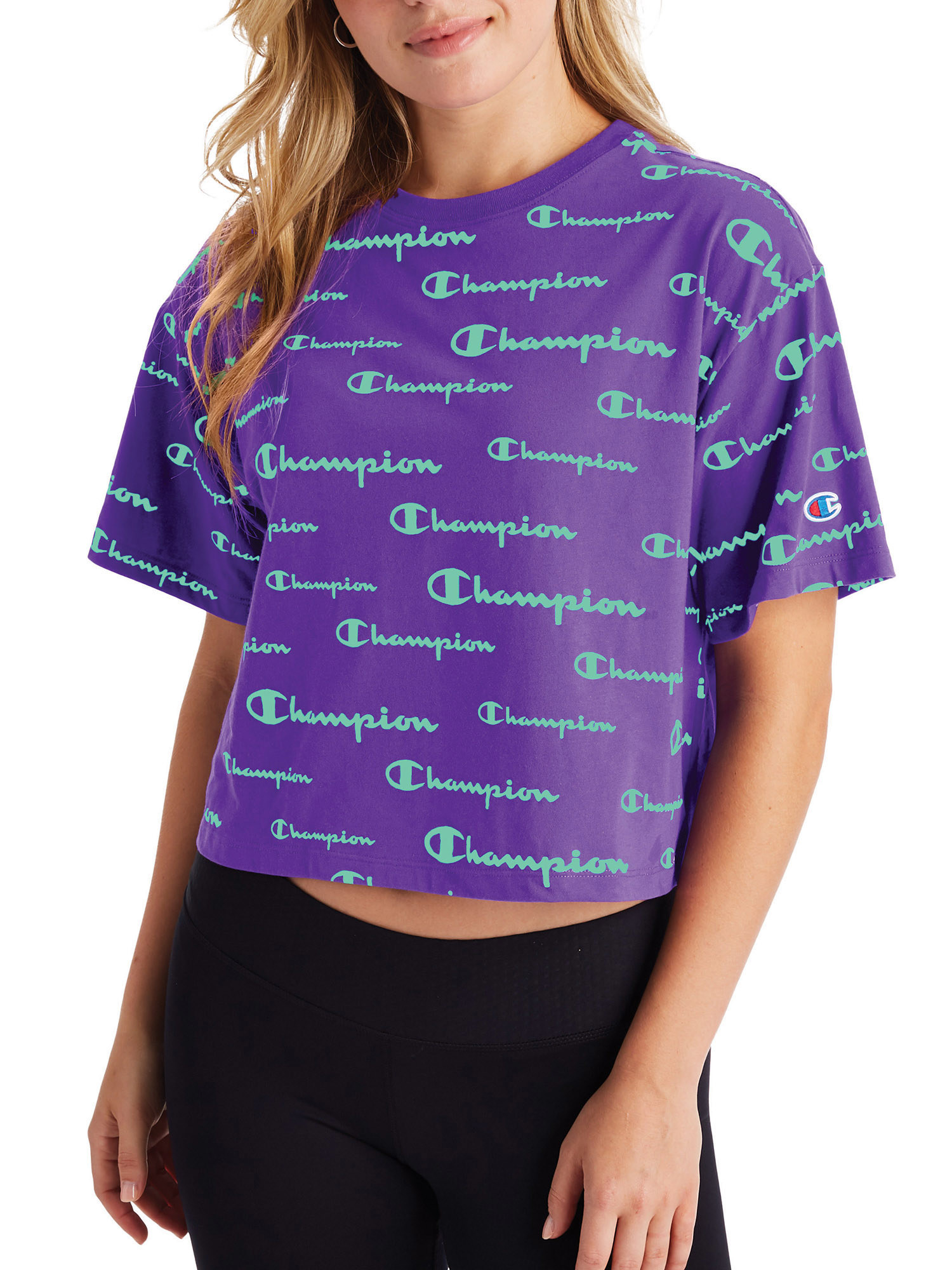 the cropped tee in purple with the champion logo all over it in green