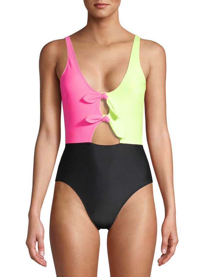 a model in a bathing suit where the top left is hot pink, the top right is neon yellow, and the bottom portion is black