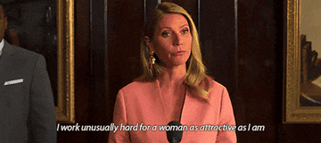 A gif from The Politician showing a close up of Gwyneth Paltrow&#x27;s character Georgina at a press conference in her bougie house wearing a neat pink blazer and saying I work unusually hard for a woman as attractive as I am