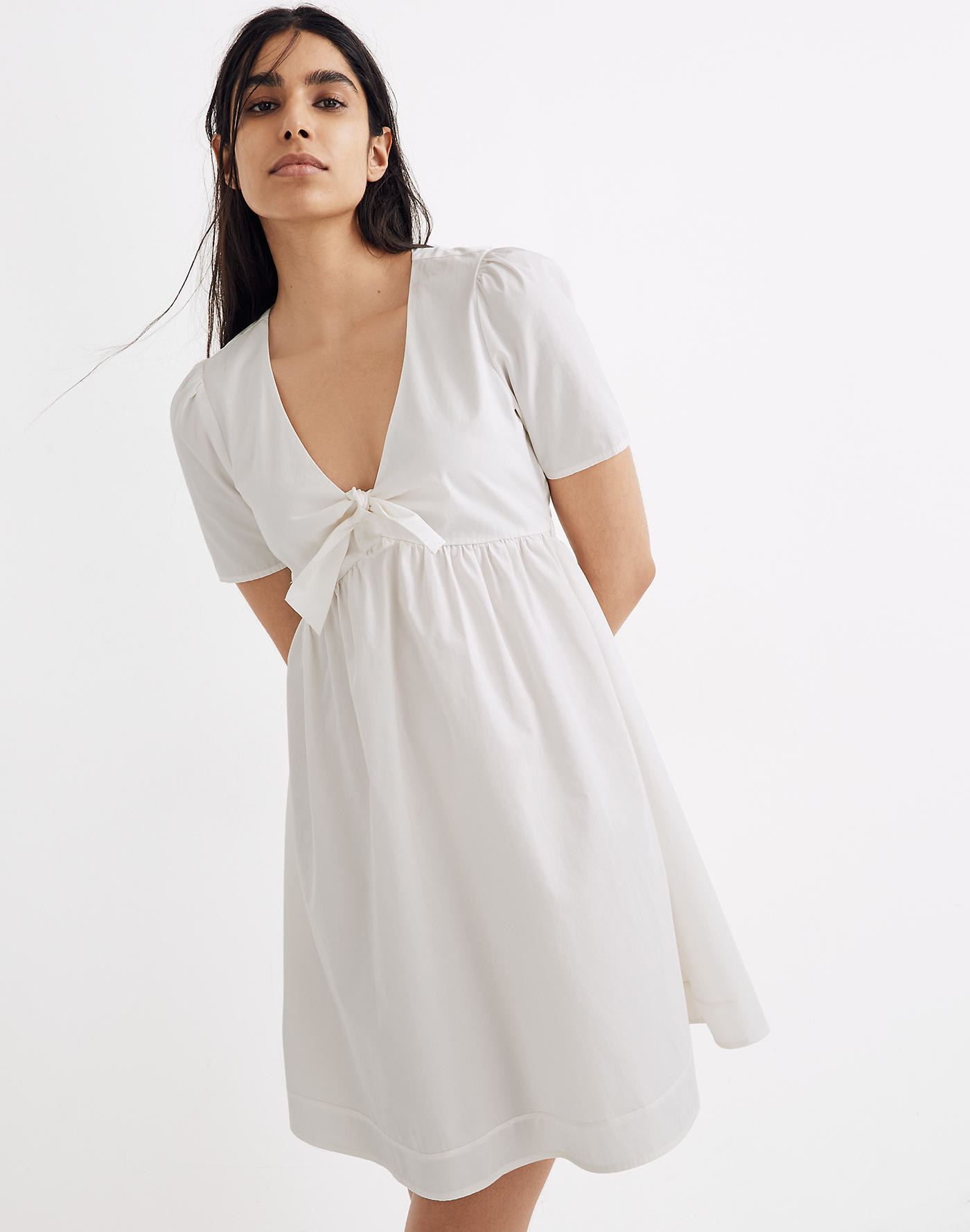 model wearing white V-neck mini dress