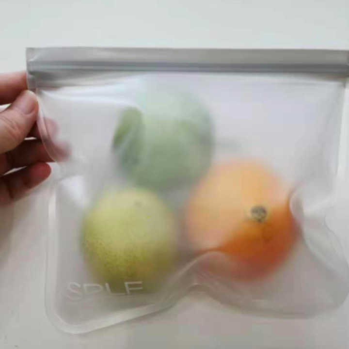 Reviewer photo showing reusable storage bag use and size with with two apples and an orange inside a single bag