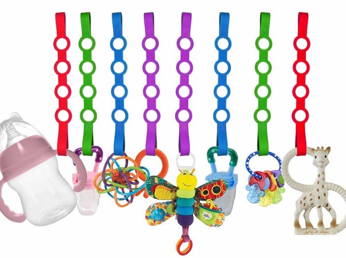 Multi-colored straps holding various baby toys and bottles