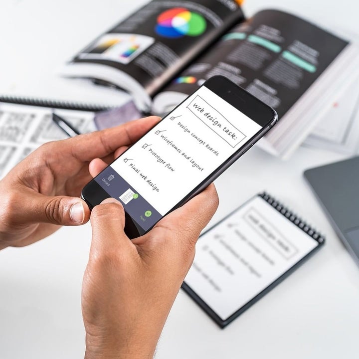 A person taking a picture of their notebook on their phone