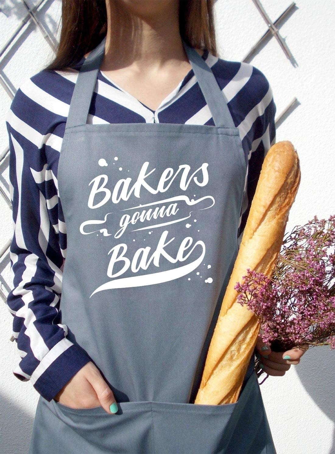 A person wearing an apron that says bakers gonna bake on it