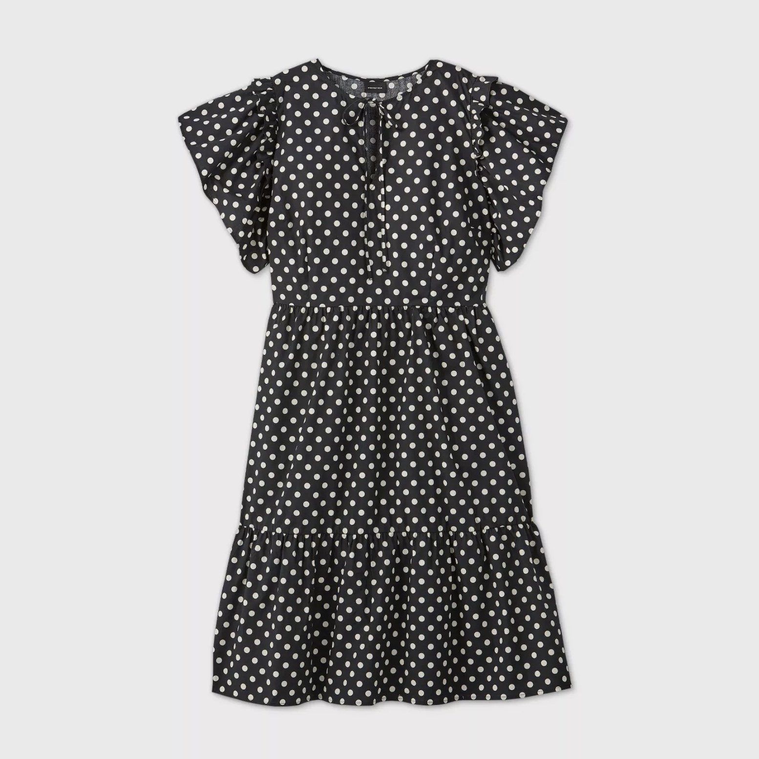An image of a black and white polka-dot dress with short ruffle sleeves and tiered hemlines