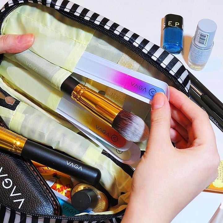 A person slides one of the files into a full makeup bag