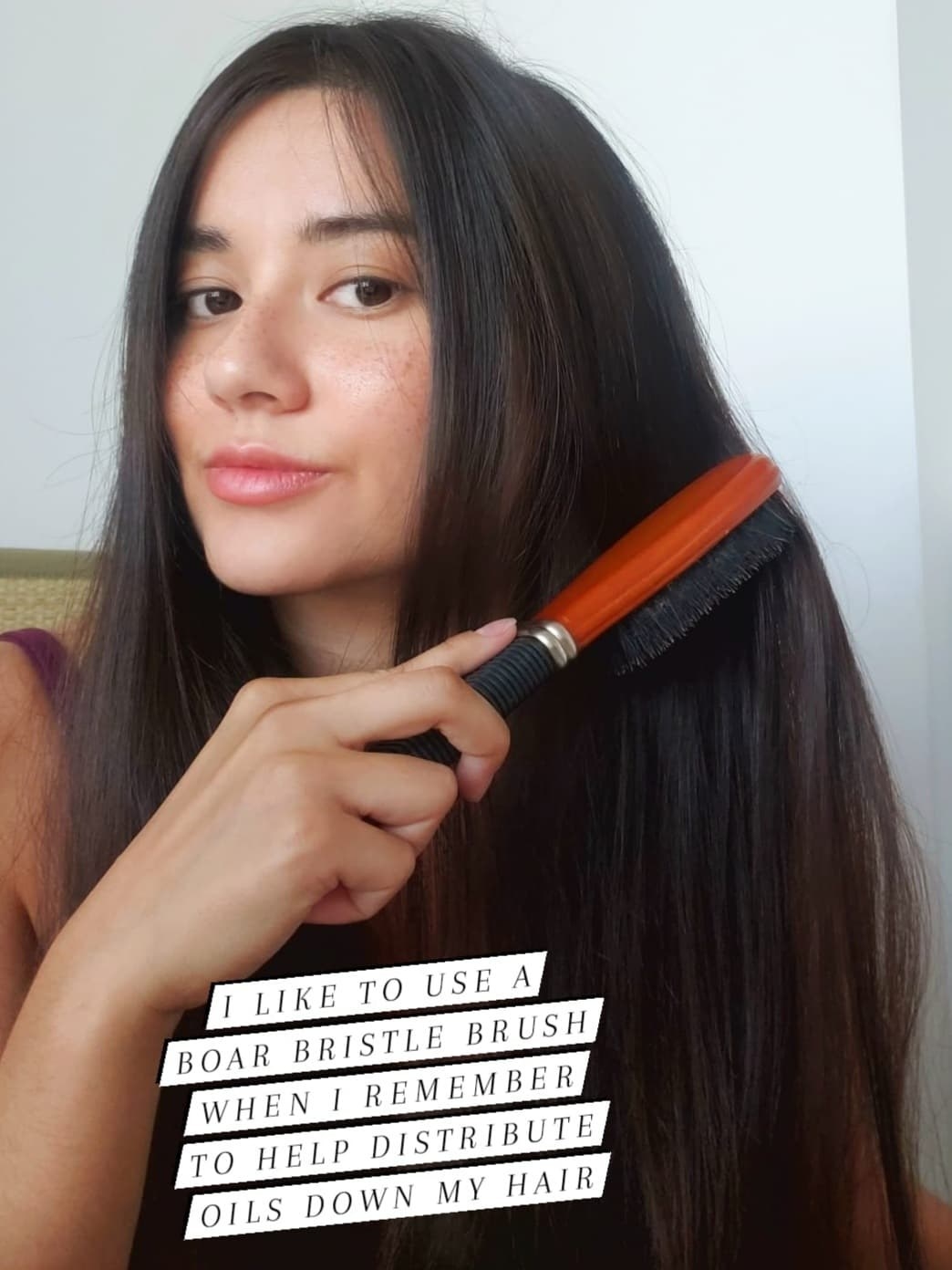 The writer uses a boar bristle brush to brush her hair, with the caption, &quot;I like to use a boar bristle brush when I remember to help distribute oils down my hair&quot;