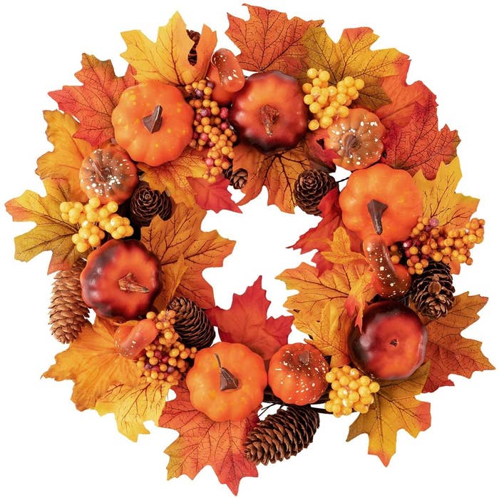 A wreath with autumn leaves pinecones and gourds