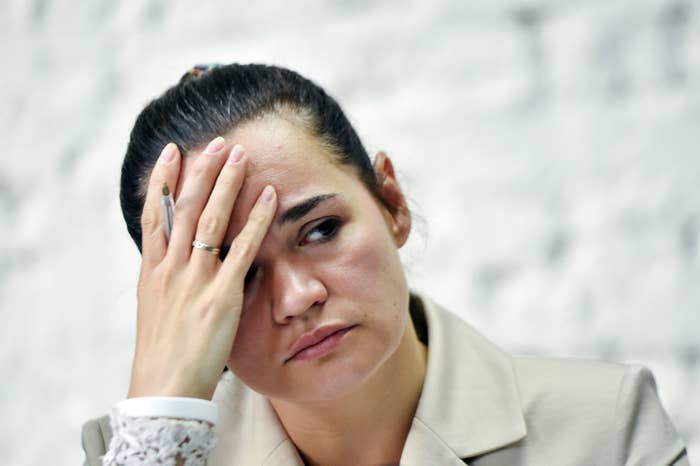 Svetlana Tikhanovskaya, with her hand on her forehead, looking very distraught