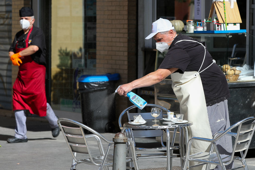  A server sanitizes chairs