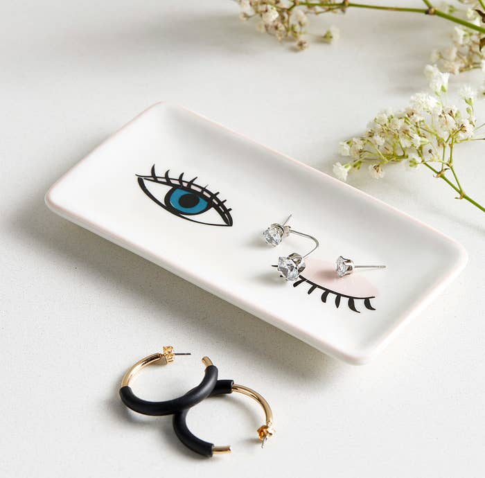 A smooth rectangular dish with earrings in it