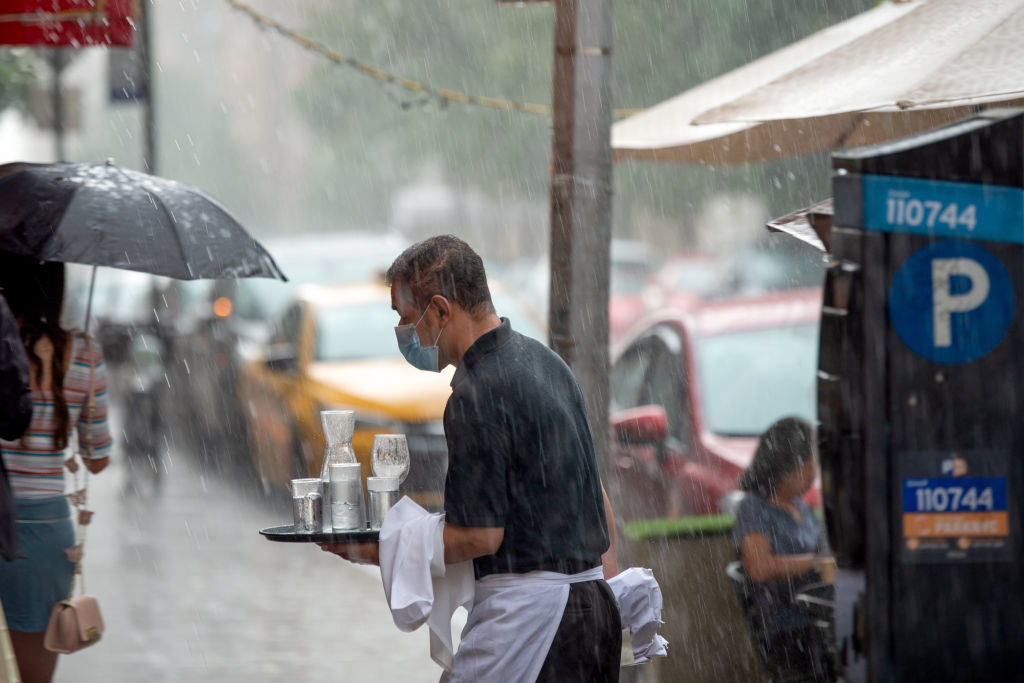 A server delivering drinks in the rain