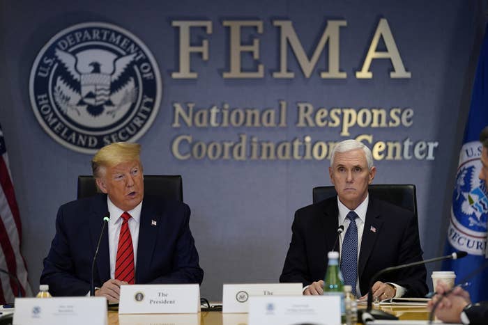 President Trump speaks while seated below the FEMA logo, with Vice President Pence by his side