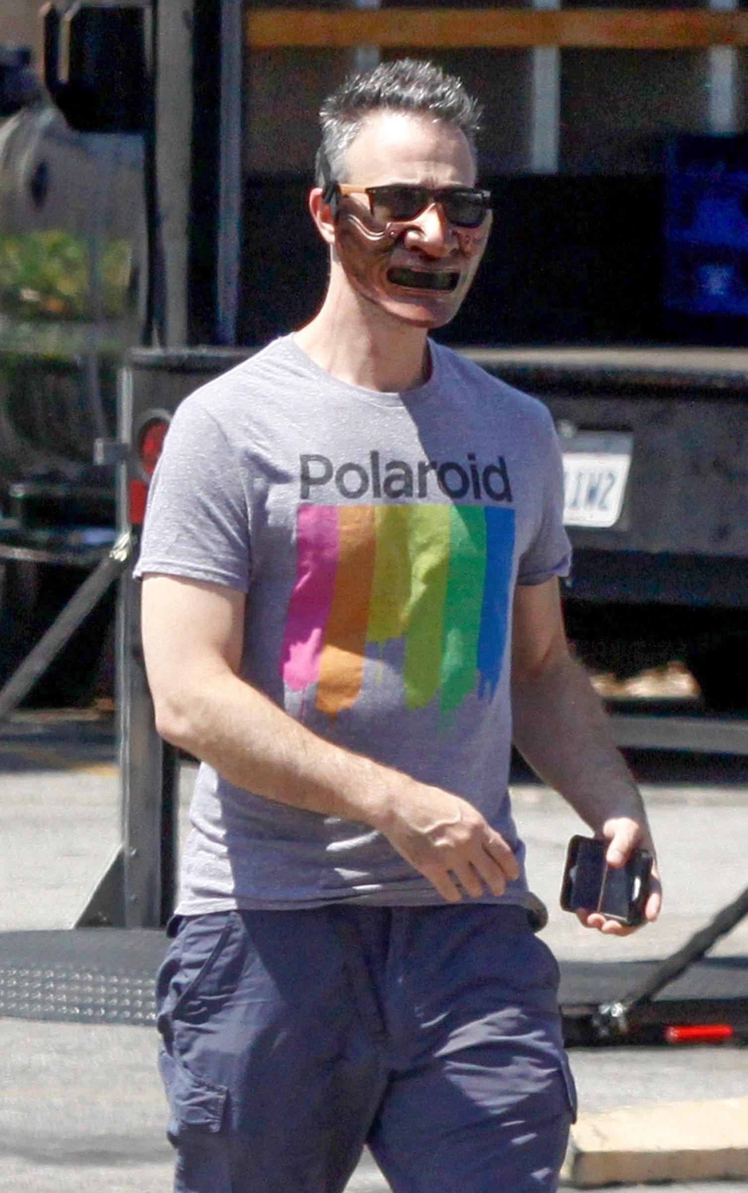 Freddie Prinze Jr. walks with a mask on that looks like half of an iron man costume.