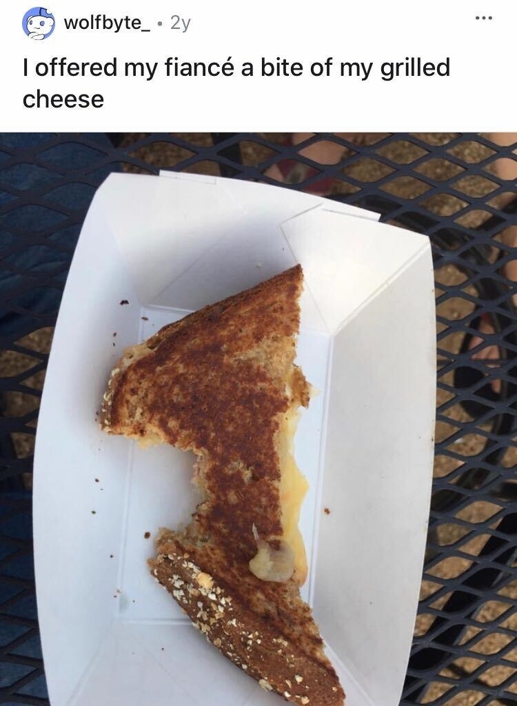 A half of a grilled cheese sandwich that&#x27;s been bitten from the crust and not from the middle