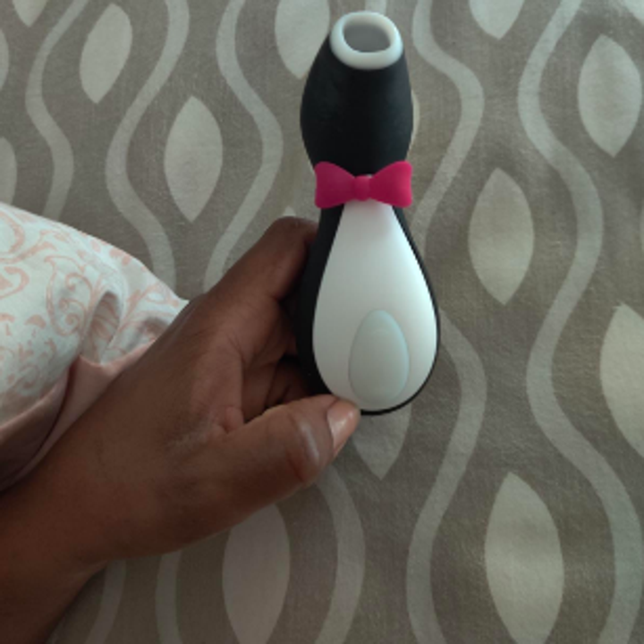 A reviewer holding the penguin-like sex toy