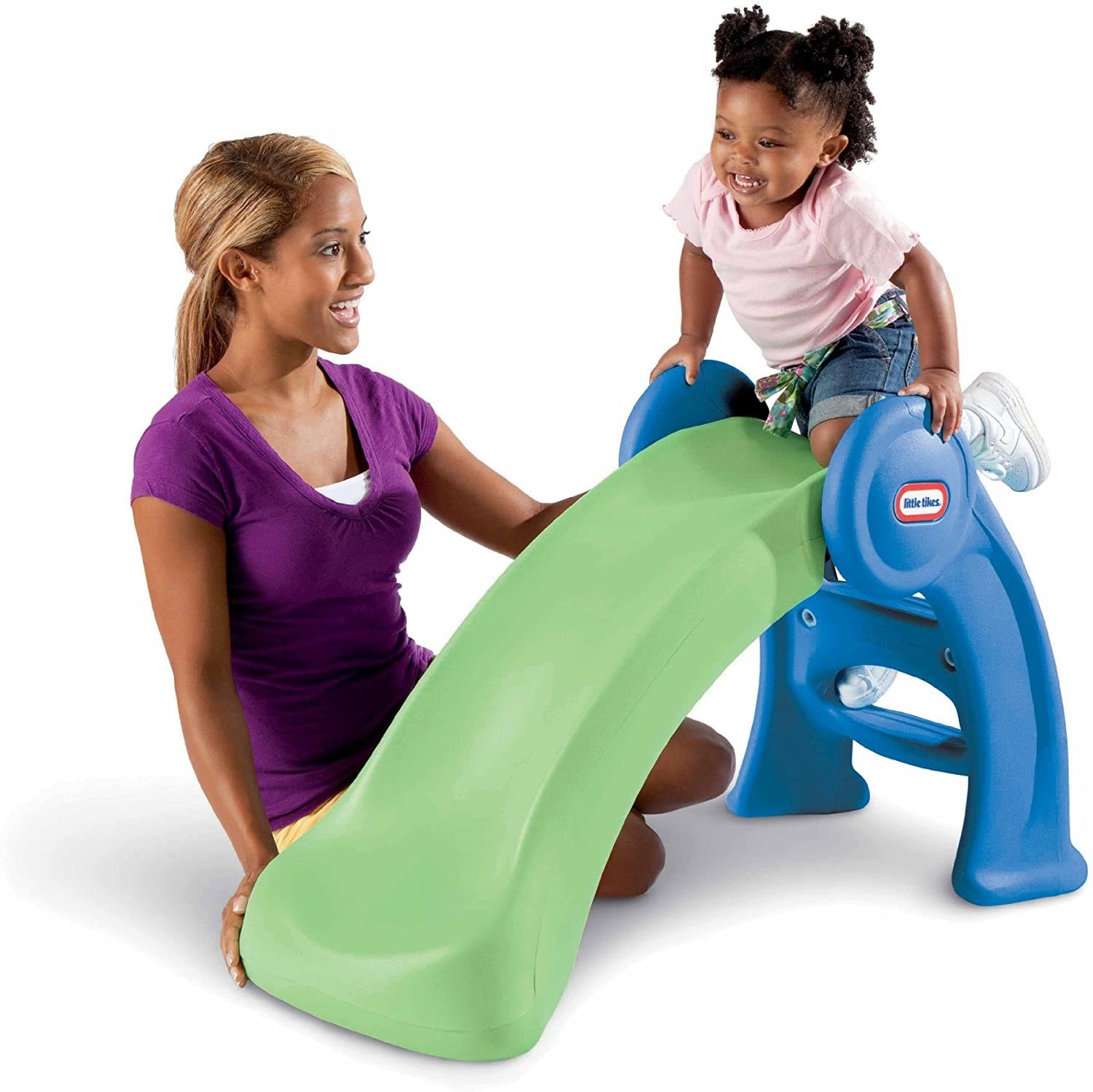 A parent watching a child play on a blue and green plastic slide
