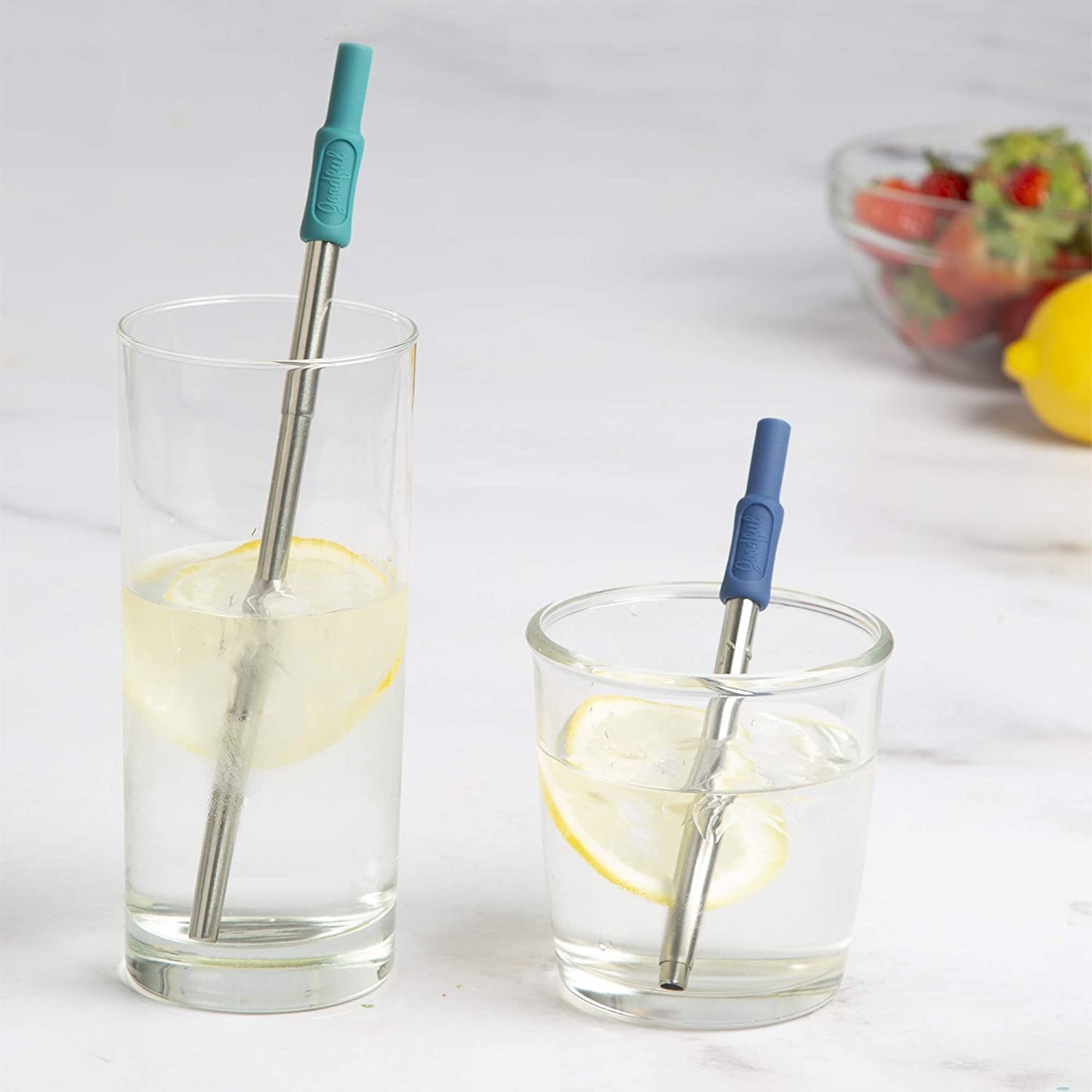 The straws placed in two glasses, one tall, one short. One straw is fully extended while the other one is collapsed