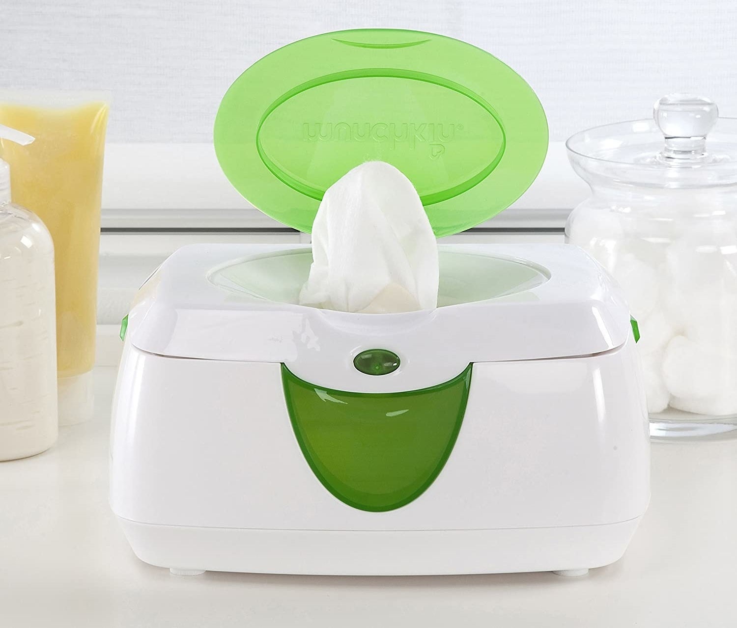 A white and green plastic wipe warmer