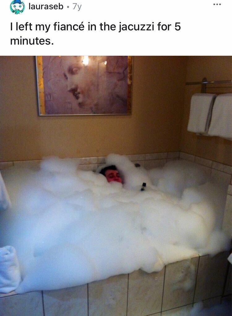 Man being engulfed by bubbles in his bathtub 