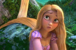 Rapunzel from Tangled with her long hair trailing behind her, draped over a pile of rocks