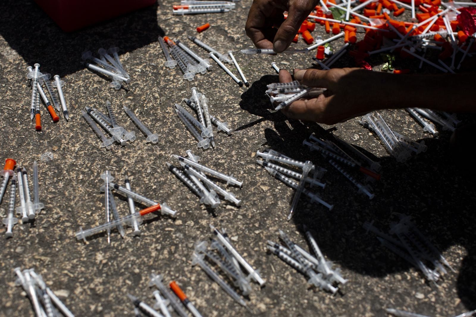 A participant counts his used needles before putting them in a safe container in exchange for new ones