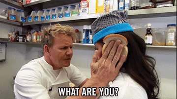 Gordon holding two pieces of bread on the sides of a woman&#x27;s head and asking her &quot;what are you?&quot; and