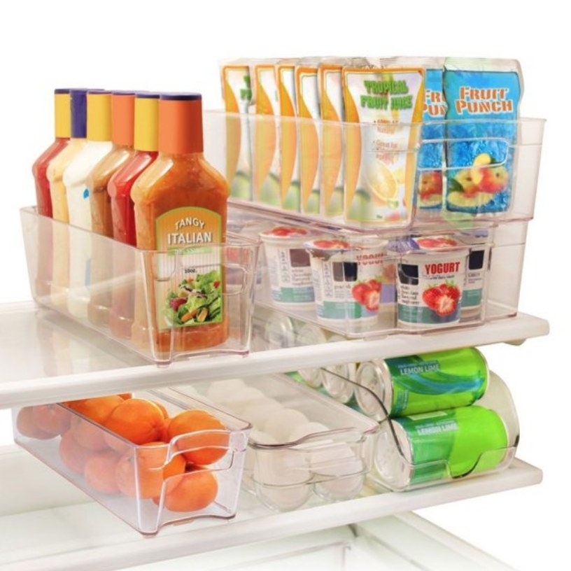 Clear plastic refrigerator organizers filled with various foodstuffs