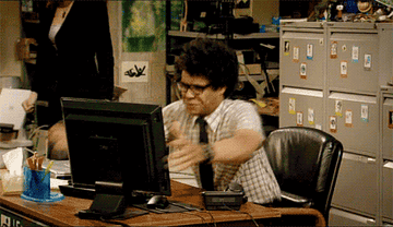 A GIF of Richard Ayoade from The IT Crowd throwing a computer monitor