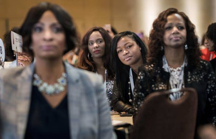 A woman leans in to get a better view of Kamala Harris on stage