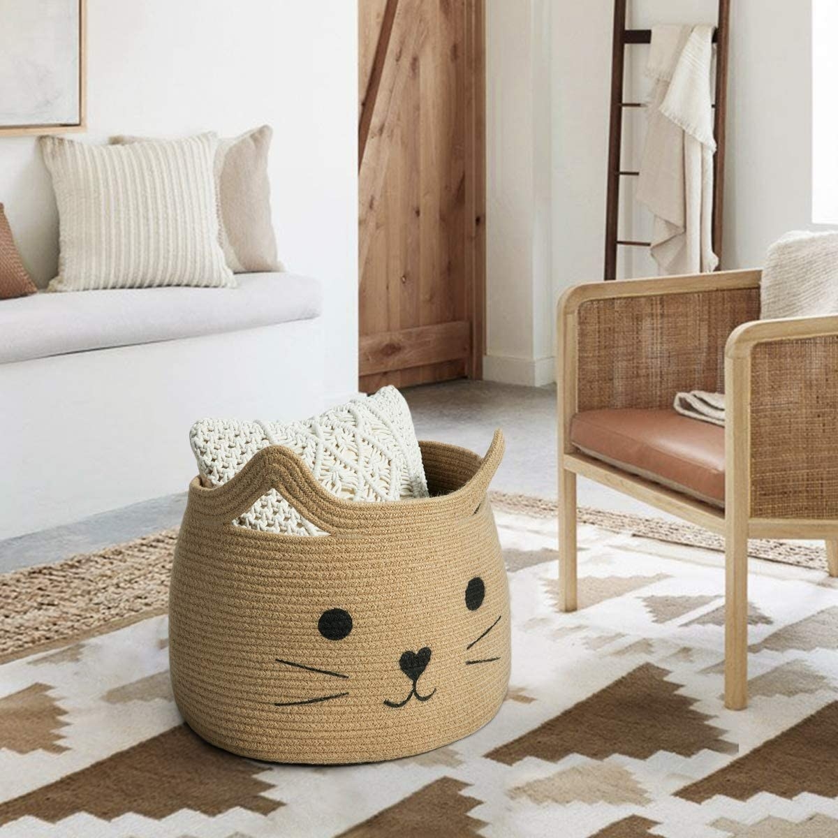 The cat-shaped rope basket in the middle of a living room with a throw pillow inside