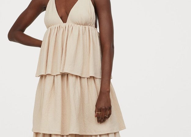 A cute and casual babydoll dress featuring a V-neck and a skirt with tiered and ruffled layers 