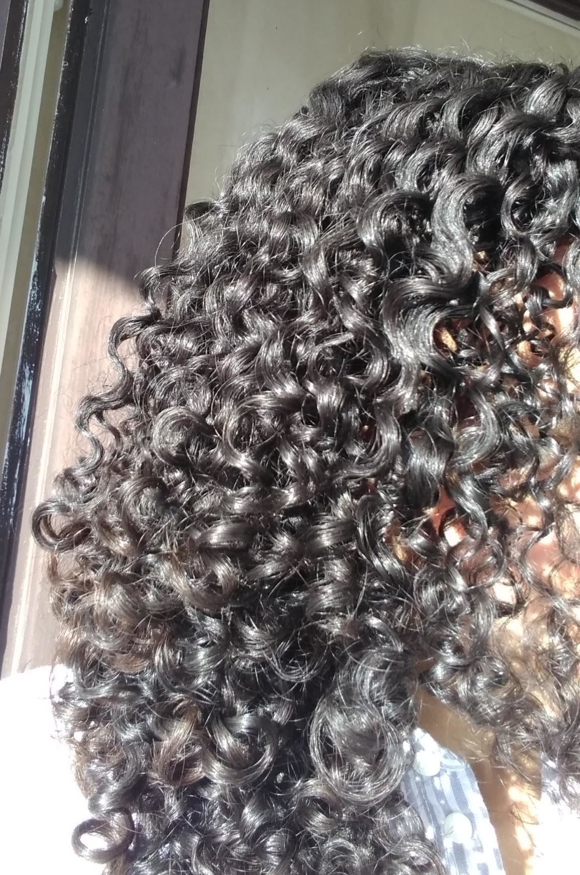 Reviewer with choky  curls showing the merchandise  adds shine