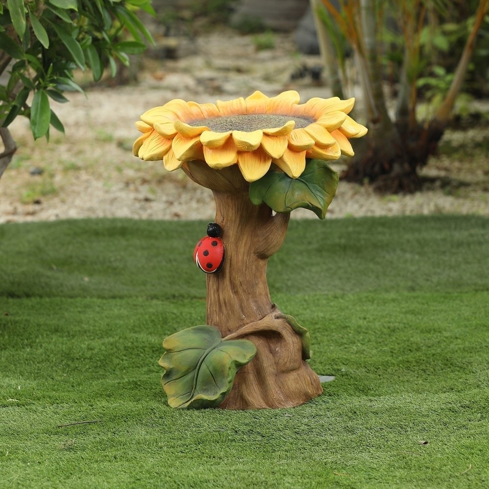 The resin bird bath that looks like a sunflower with a space on top for the bath; a ladybug figure crawls up the side