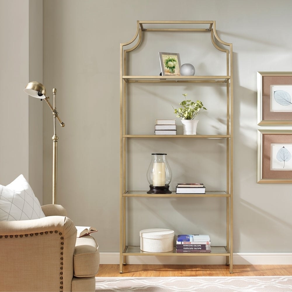 A gold etagere bookshelf with four shelves