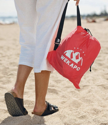 A model holding the lounger in a small bag when the air is let out 