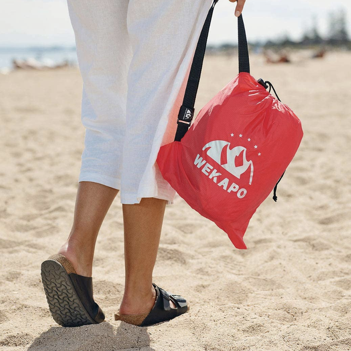 A model holding the lounger in a small bag when the air is let out