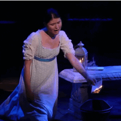 Phillipa Soo in Hamilton holding a paper that is on fire 