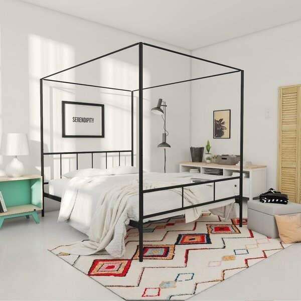 A black metal piping bed frame with a straight headboard and baseboard and connected canopy piping above 