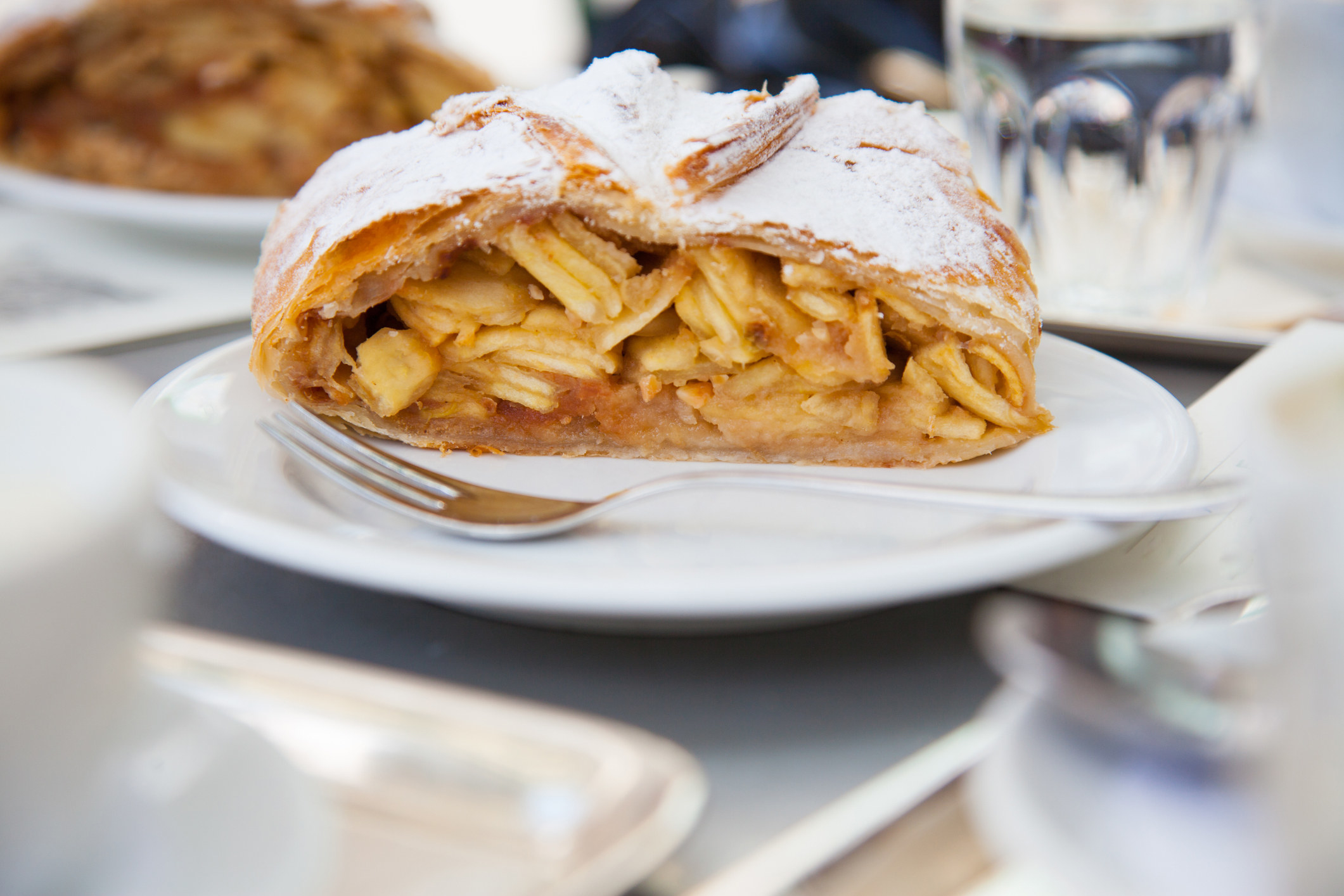 a slice of apple strudel with a golden-brown pastry and thin slices of apple inside
