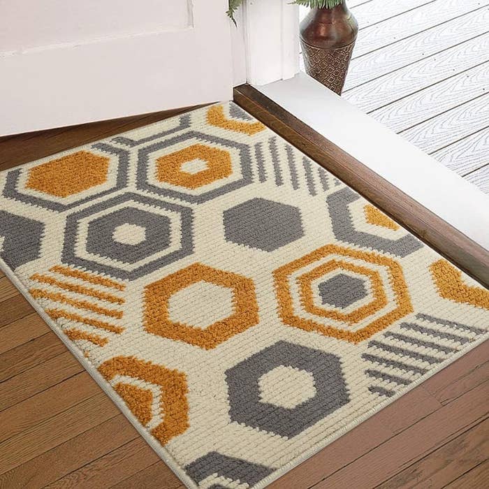 A cream-colored rug with orange and gray geometric shapes