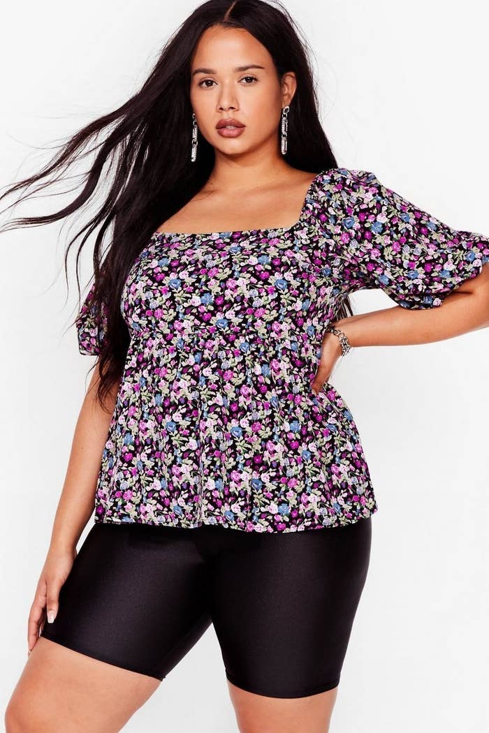 model wearing purple black and blue floral top