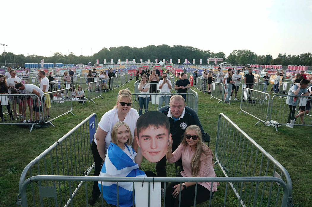 People with a cut-out giant head in a pod