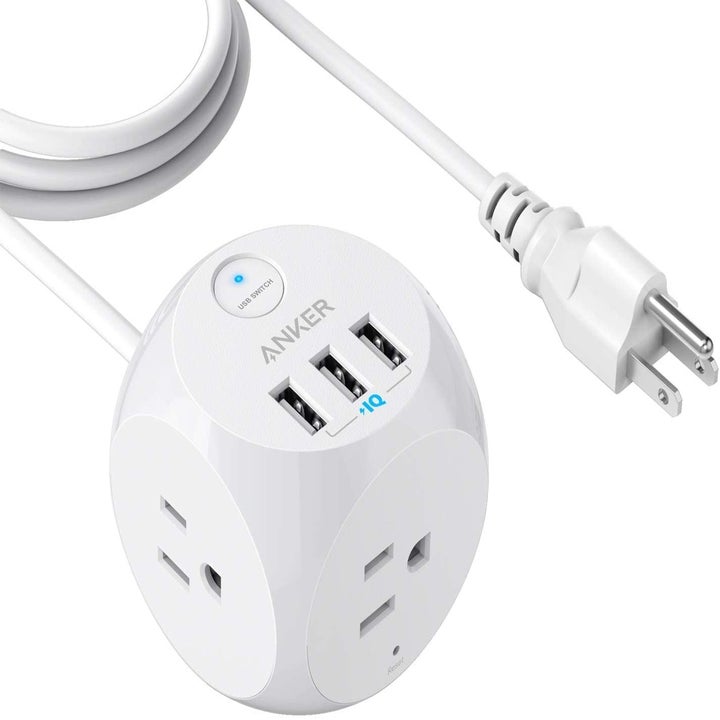 A white cube charger with plugs and USB ports