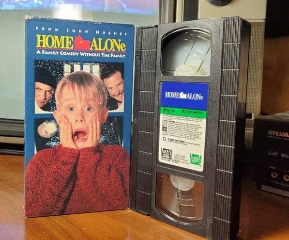 The VHS sleeve for "Home Alone" which features the movie's poster on it next to the VHS of the movie itself.