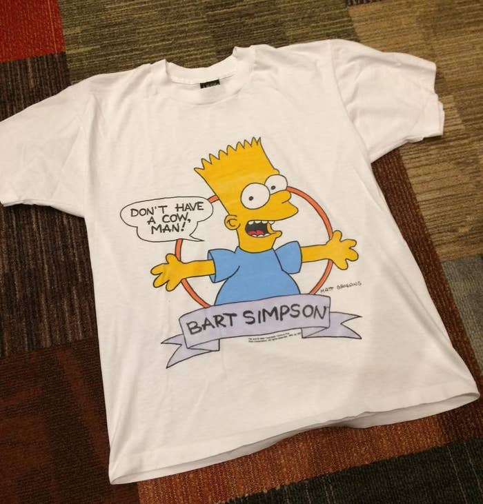 A white T-shirt with Bart Simpson on it saying "Don't have a cow man!"