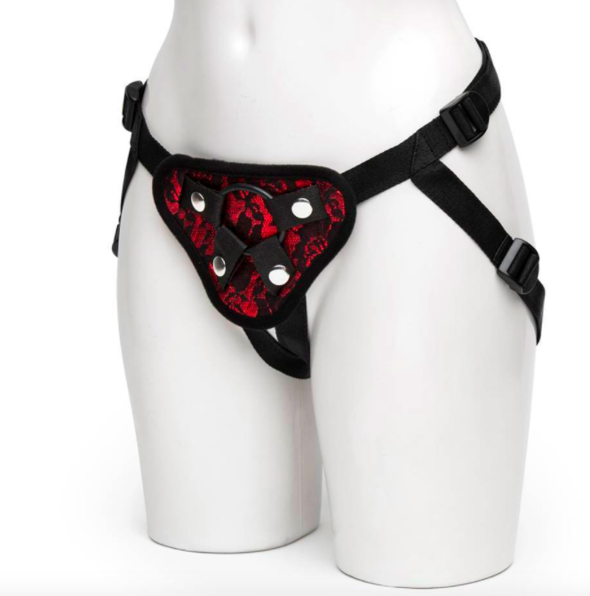 Mannequin wears black and red lace strap-on harness with a black O-ring in the middle