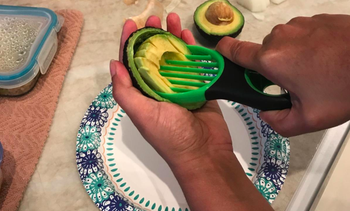 A reviewer slicing an avocado with the slicer