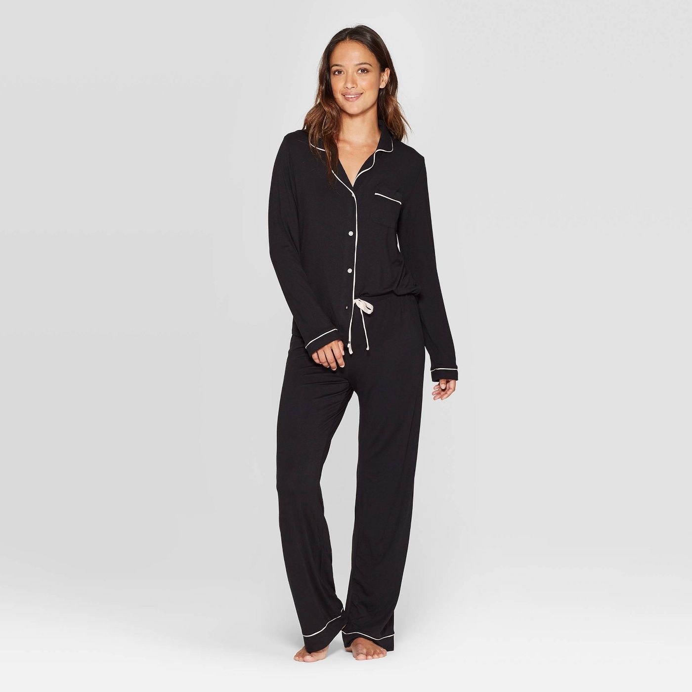 model wearing matching black pants and button-up top pajamas