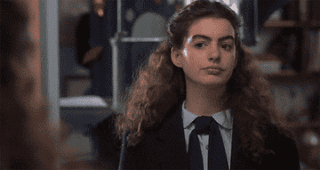 A GIF of Anne Hathaway lifting her eyebrow in The Princess Diaries